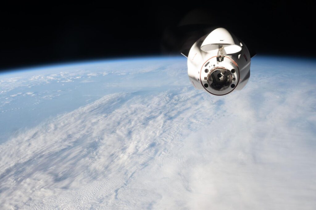 An earlier SpaceX Dragon cargo spacecraft with its nose cone open approaches the International Space Station (SpaceX's 34th resupply flight).