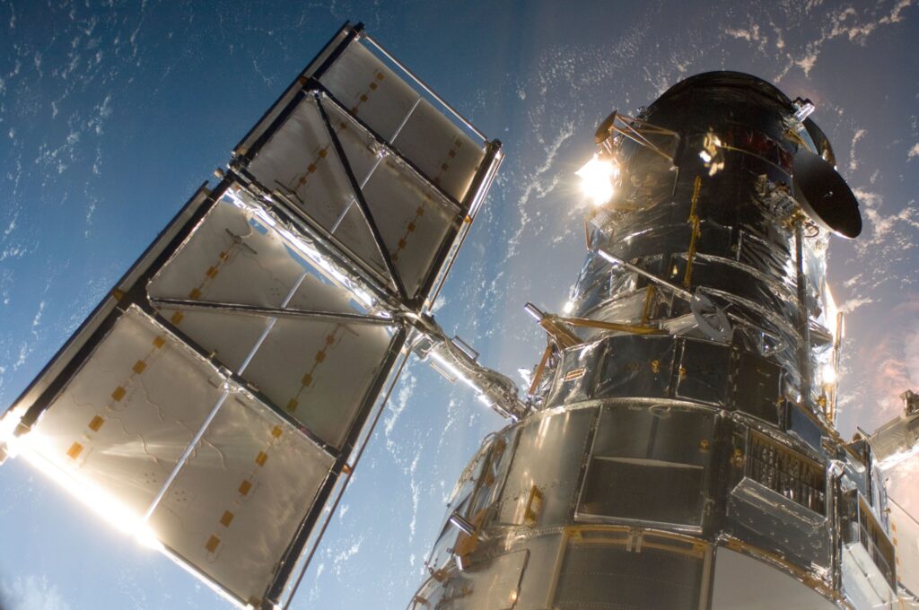 The Hubble Space Telescope in orbit above Earth, seen from a space shuttle
