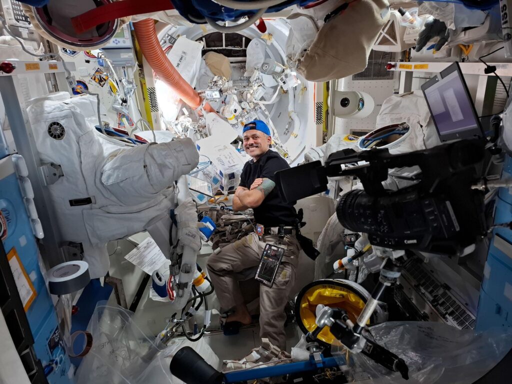 Astronaut Anil Menon doing spacesuit maintenance inside the Quest airlock