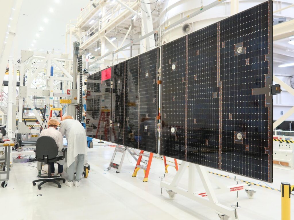 Technicians inspect a solar array wing for the Orion service module at Kennedy Space Center, Aug. 18, 2026