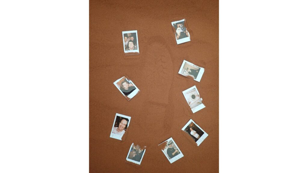 Photos arranged by the CHAPEA Mission 2 crew around a boot print in the simulated Martian sand outside the habitat