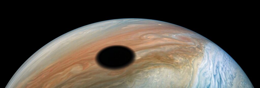 The moon Io casting its shadow on Jupiter's cloud tops