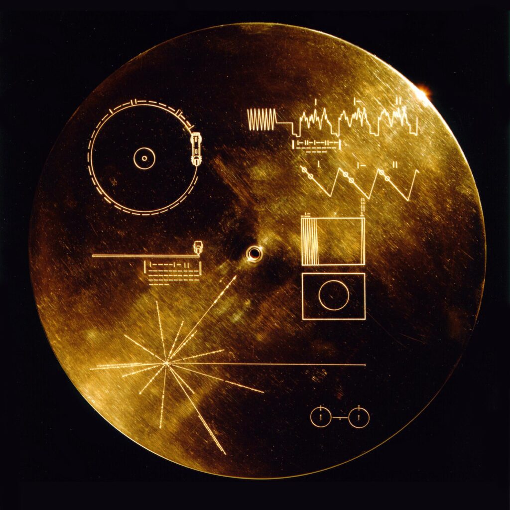 A round gold plate with diagrams explaining how to play the Golden Record and the location of Earth