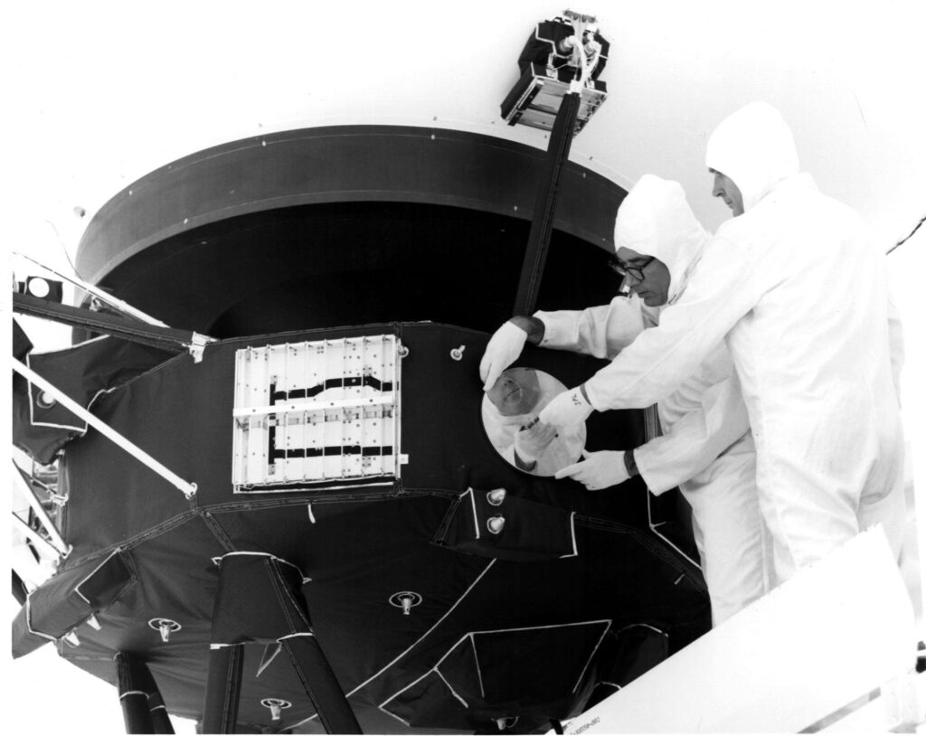 Engineers secure the cover over the Voyager 1 Golden Record in an archival 1977 image